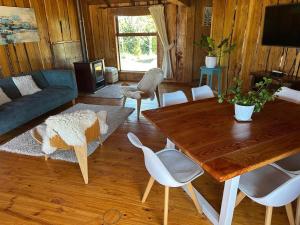 a living room with a wooden table and chairs at Cabañas Kuela in Puerto Varas