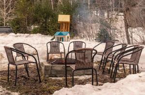 a group of chairs around a fire pit in the snow at Spa - Waterfront - La Source in Saint Come