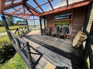 a wooden porch of a cabin with chairs on it at Cabañas Kuela in Puerto Varas