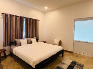 a bedroom with a bed and a large window at Modern Elephant Lagoon Villa in Ko Chang