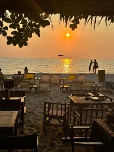 a sunset on the beach with tables and chairs at Modern Elephant Lagoon Villa in Ko Chang