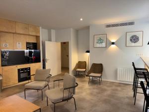 a living room with chairs and a table and a kitchen at Urban Cube Hostel Granada in Granada