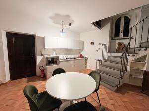 a kitchen with a white table and chairs and stairs at DIMORA MedioEvo in Orvieto +18 photos
