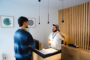 a man standing at a cash register in a store at Urban Cube Hostel Granada in Granada