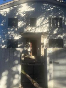 a white house with a door in front of it at Tamika's House in Udine