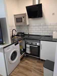 a kitchen with a washing machine and a microwave at Las vegas in Alcorcón