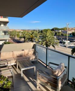 a balcony with a couch and a table and chairs at Flo location Fréjus in Fréjus