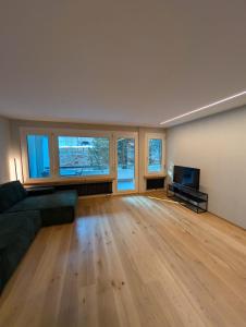 an empty living room with a couch and a television at Ferienwohnung Flumserberg, Liftnähe & Gratis Parkplatz in Flumserberg +33 photos