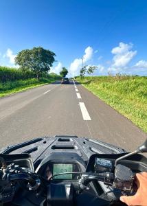 a person riding a motorcycle down the road at La Kawannaise Blue Lagon - Piscine, Wifi, Plage, Terrasse in Grand-Bourg
