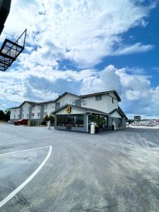 a large building with a parking lot in front of it at Super 8 by Wyndham Corbin KY in Corbin