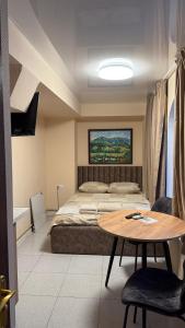 a bedroom with a bed and a table in it at APETIKO APARTMENTs in Kyiv