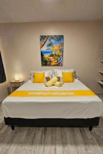 a bedroom with a large bed with yellow pillows at Raiatea Sunrise villa in Taputapuapea