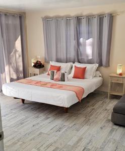 a bedroom with a large bed with red and white pillows at Raiatea Sunrise villa in Taputapuapea