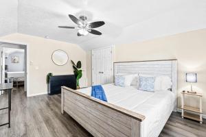 a bedroom with a large bed with a ceiling fan at Cozy 2BR - Beach & Trail - Bikes, Fire Pit in St. Petersburg
