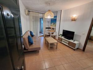 a living room with a couch and a television at Sol y Mar Fuengirola in Fuengirola