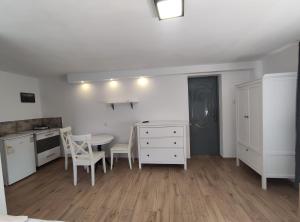 a room with a table and chairs and a kitchen at Noclegi Piaskowa 44 in Nowa Karczma