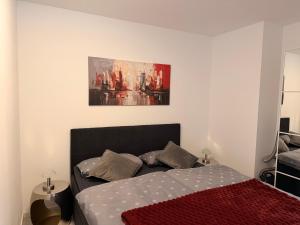 a bedroom with a bed and a painting on the wall at Komfortable moderne Ferienwohnung 43 qm in Köditz