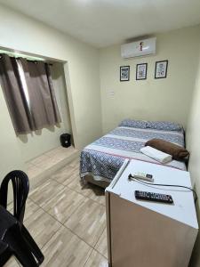 a bedroom with a bed and a desk with a keyboard at Rioli quarto 2 in Caruaru