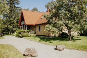 a house with two large rocks in front of it at Viesu nams Smēdes in Limbaži