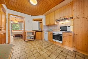 a large kitchen with wooden cabinets and appliances at Haus Martin Appartement Eichhörnchen in Ramsau am Dachstein