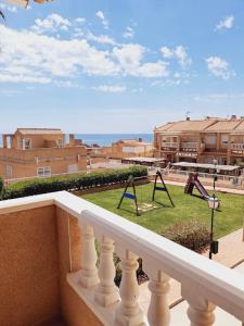 a balcony with a view of a yard with swings at Altos del Mar in Santa Pola