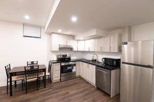 a kitchen with a table and a stainless steel refrigerator at New Basement Apartment with parking in Oakville