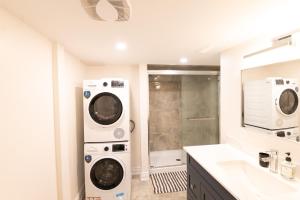 a bathroom with a washer and dryer next to a sink at New Basement Apartment with parking in Oakville