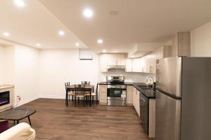 a kitchen with a stainless steel refrigerator and a table at New Basement Apartment with parking in Oakville +10 photos