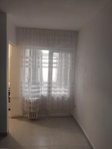 a room with a door with curtains and a window at Studio Relax2 in Bacău