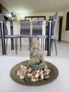 a statue of a buddha sitting on a plate at Casa completa Comodidad-Ubicación Perfecta-CarmenV in Carmen de Viboral