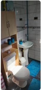 a bathroom with a toilet and a sink at Hospedaje Sandra in Llanquihue