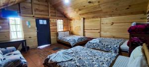 a room with three beds in a log cabin at Cabañas Paraiso tziscao in Comitán