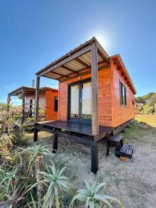 a tiny house on a trailer with a large deck at La pinta roja in Punta Del Diablo