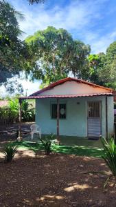 a small house with a chair in front of it at Chalé Rústico Cumuruxatiba in Cumuruxatiba