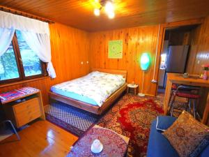 a small bedroom with a bed and a table at MERIKOTKA - a cozy wooden cottage, sLOVEnia in Braslovče