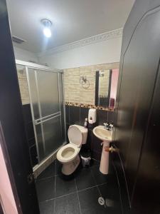 a bathroom with a toilet and a sink at Hotel El paraiso Funza in Funza +23 photos