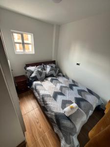a bedroom with a bed with a comforter and a window at Hotel El paraiso Funza in Funza