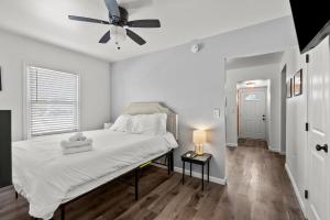 a white bedroom with a bed and a ceiling fan at Mint Julep - Studio in Downtown Lexington in Lexington