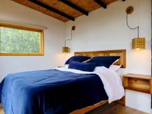 a bedroom with a blue and white bed and a window at Ziatá in Simijaca +16 photos
