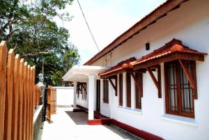 une maison avec une clôture en bois à côté dans l'établissement Miura Dutch Edge Hotel, à Negombo