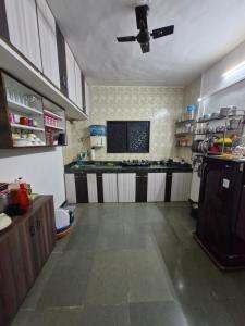 a large kitchen with a ceiling fan in a room at Laximi Niwas in Nashik +3 photos