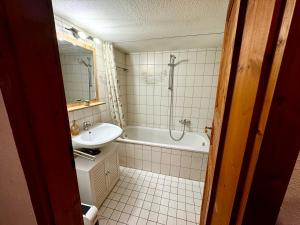 a bathroom with a tub and a sink and a bath tub at Genau so - Allgäu! Sau Gemütlich in Maierhöfen +8 photos