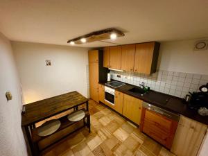 a small kitchen with wooden cabinets and a wooden table at Genau so - Allgäu! Sau Gemütlich in Maierhöfen