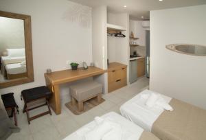 a bedroom with a bed and a desk and a mirror at Horizon Kalymnos in Myrties +48 photos