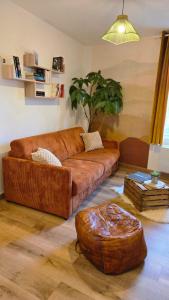a living room with a brown couch and a ottoman at Le Royal Billy in Dreux +36 photos