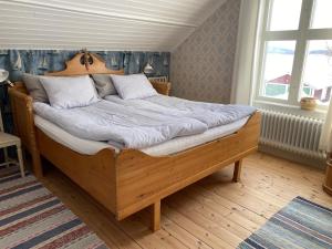 a bedroom with a wooden bed in a room at Charmig stuga på bondgård in Norrfjärden