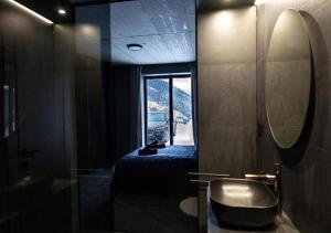 a bathroom with a bed and a mirror and a window at JASNÁ Luxury Apartments with Mountain View in Belá