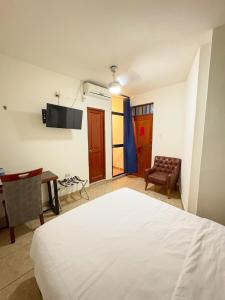 a bedroom with a bed and a table and a chair at Hospedaje Gran Imperial in Tumbes