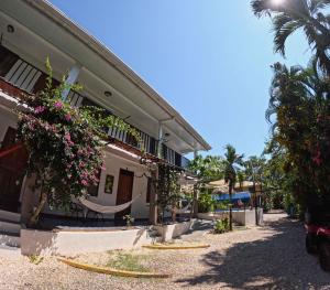 a building with a hammock outside of it at La Posada - Hostel in Santa Teresa Beach