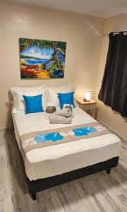 a bedroom with a large bed with a painting on the wall at Raiatea Sunrise villa in Taputapuapea